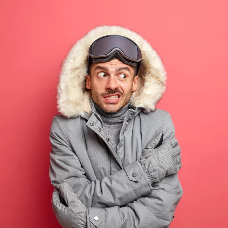 handsome-puzzled-unshaven-man-skier-shievers-trembles-cold-frosty-day-hates-winter-cold-wears-snowboard-goggles-grey-jacket
